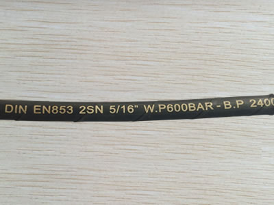 A section of DIN EN853 2SN hydraulic hose is on the table.