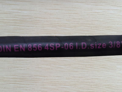 A section of DIN EN856 4SP hydraulic hose is on the table.