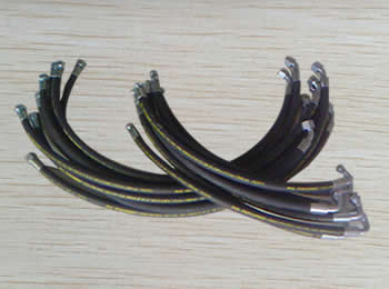 Several SAE 100 R1 A hydraulic hose assemblies are on the ground.