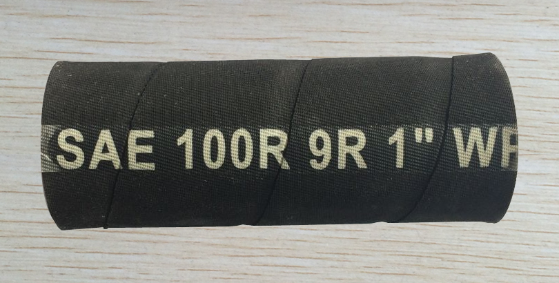 A section of SAE 100 R9 hydraulic hose is on the table.